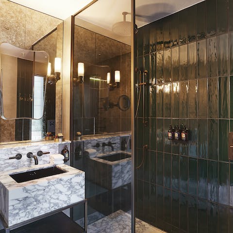 Relish a rain shower in your gorgeous green tiled and marvellous marble bathroom