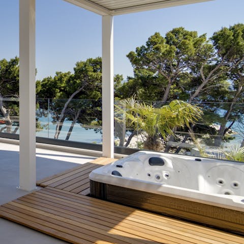 Sink into the bubbling hot tub and watch the trees sway gently in the soft sea breeze as the sun goes down