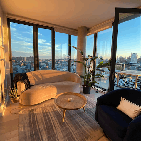 Enjoy golden hour in the glass-walled living room at the top of the city
