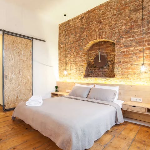 Sprawl out on the comfy bed and admire the exposed brick walls surrounding you