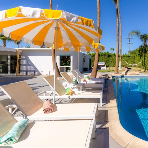 Relax by the pool under the shade of the stylish parasol 