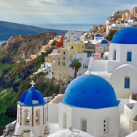 Explore Santorini's charming villages, dotted with blue domes