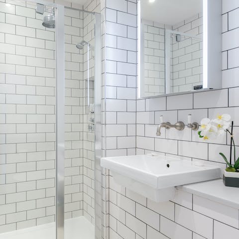 Start mornings in the metro-tiled bathroom with a luxurious soak under its rainfall shower