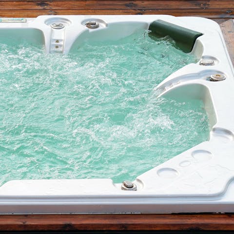 Take a dip in the alfresco hot tub, glass of champagne in hand