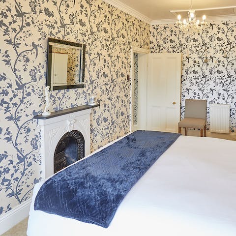 Admire the Victorian-style floral wallpaper in the bedroom