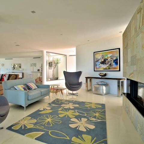 Relax in style on mid-century chairs in front of the fireplace