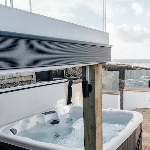 Relax in your private six-person hot tub with sea views