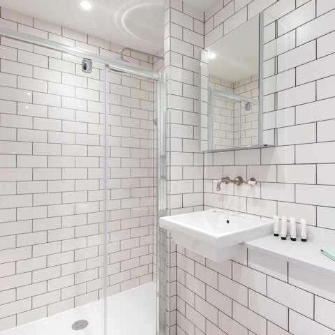 Start mornings with a relaxing soak under the metro-tiled bathroom's rainfall shower