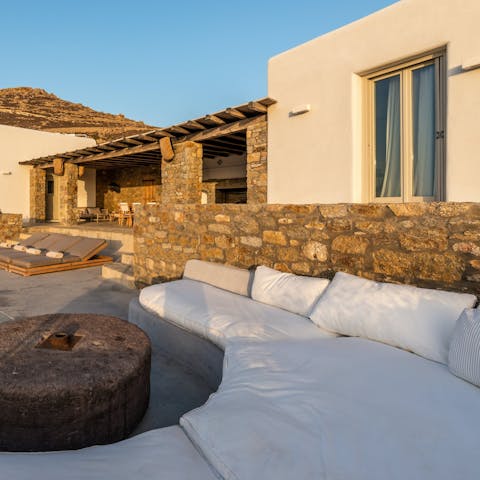 Watch the sun set over the Aegean on the white built-in sofa