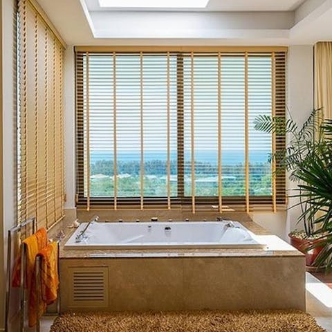 Soak in the luxurious jacuzzi tub with the serene jungle view