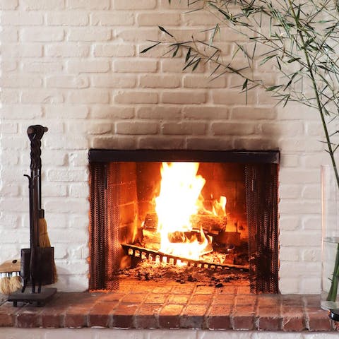 Snuggle up by the living room's fire with a glass of wine on cooler evenings
