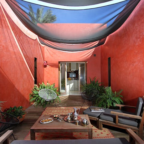 Relax in the intimate enclosed courtyard with its rich red hibiscus-hued walls