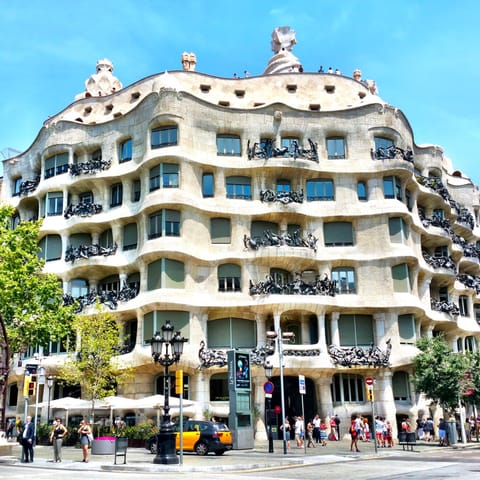 Walk up to the iconic Casa Mila and admire the striking historic architecture