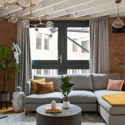 Kick back in the industrial-chic living area with painted rafters and exposed brickwork