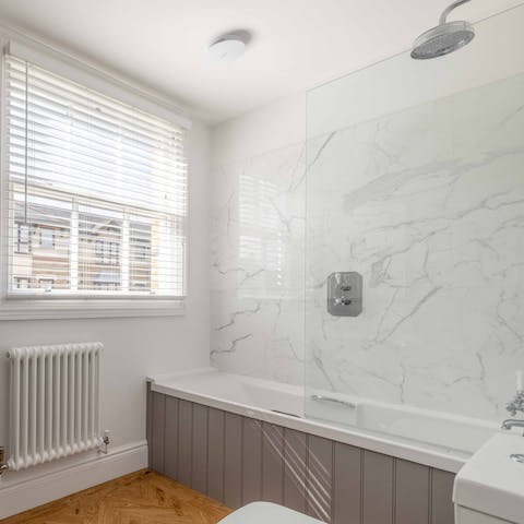 Have a soak in the tub in the bathroom with its marble-style tiles