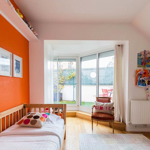 Let the kids play with the toys in the bedroom with its vibrant orange decor 