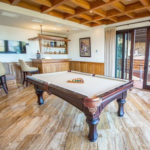 Play pool as family members watch on from the wet bar