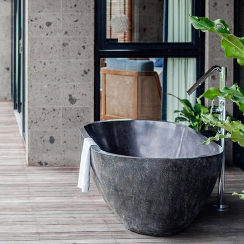 Sink into the luxurious stone standalone tub out on the balcony