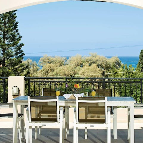 Gather around the outdoor table to share fresh juice overlooking the sea