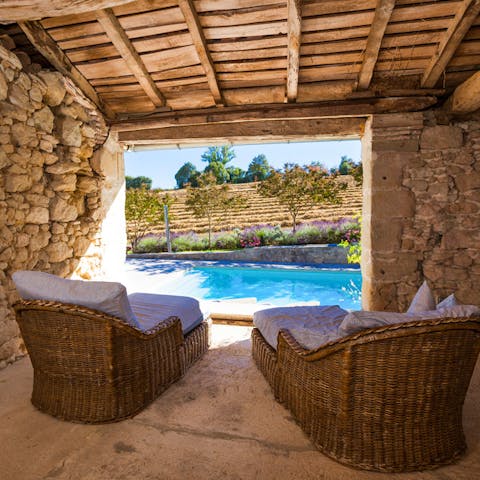 Relax in the shaded lounge area while you enjoy the views of the swimming pool and the gardens beyond