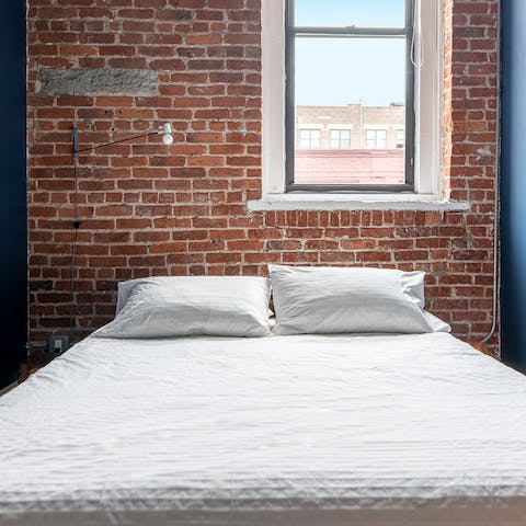 Fall asleep next to exposed brick in the snug bedroom