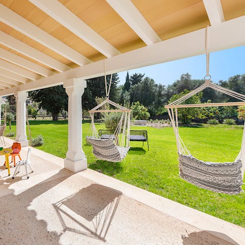 Swing in the hammocks while the kids play on the grass with the included toys under the hot Mallorcan sun