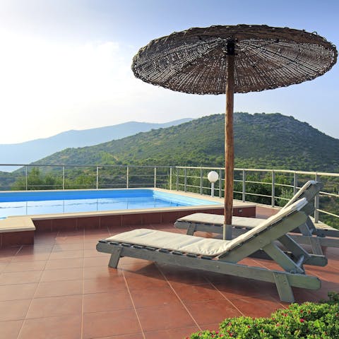 Lounge by the pool surrounded by breathtaking views of the surrounding mountains