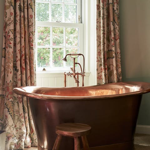 Unwind with a soak in the lush copper bathtub, appreciating the views out the window