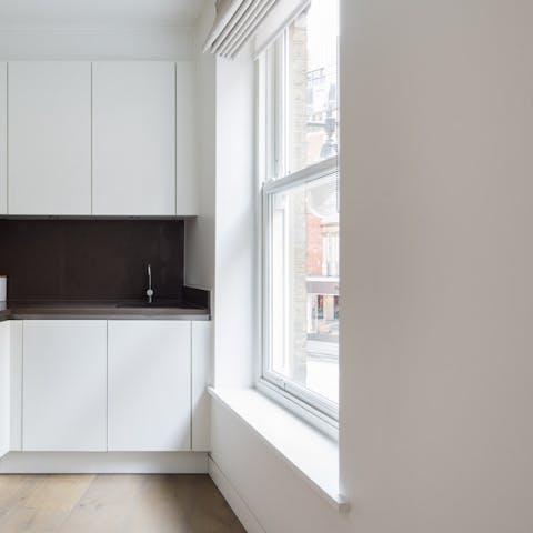 Prepare a wholesome breakfast by the huge windows in the glossy kitchen