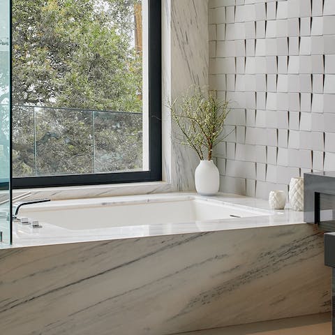 Treat yourself to a long soak in the truly indulgent marble bathtub