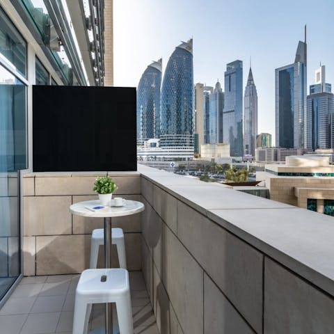 Gaze up at the skyscrapers over a revitalising cup of coffee on the private balcony