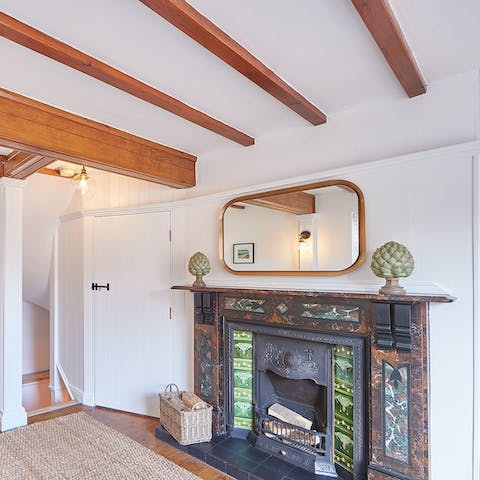 Get cosy around the striking fireplace, below original wooden beams