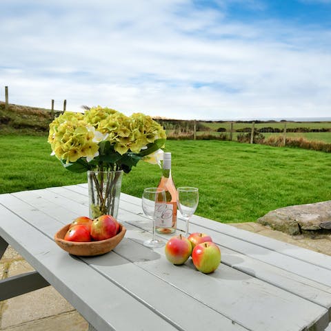 Pour a glass of rosé and bask in the countryside views on the sun-kissed patio