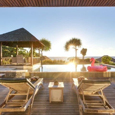 Enjoy cocktails with sunset views from the pool area