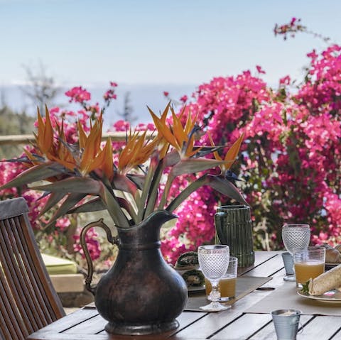 Enjoy drinks alfresco, admiring the sea views through the pink bougainvillea