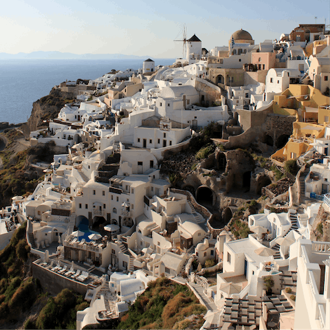 Explore Oia's cascading white sugar cube buildings clinging to the cliffs, a fifteen-minute drive away 