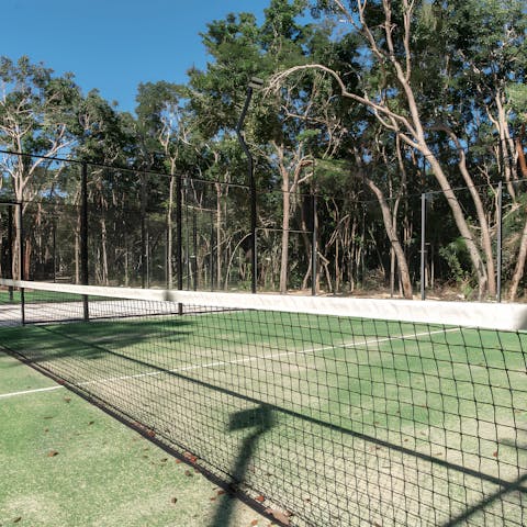 Practise your swing at the on-site tennis court surrounded by tropical greenery