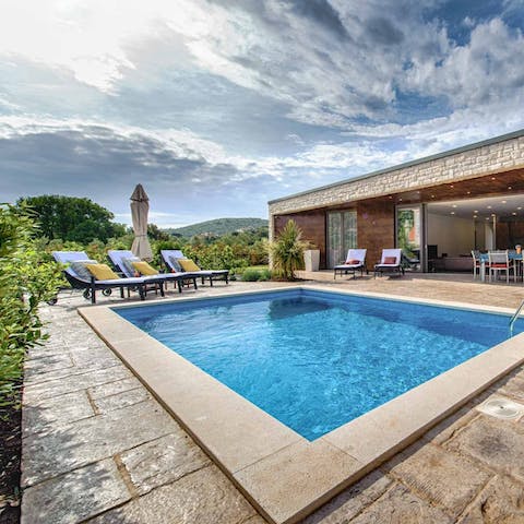 Drink up the rolling hillside views from the private poolside