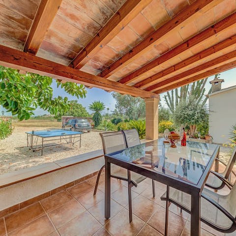 Watch a game of ping pong as you shade yourself on the covered terrace