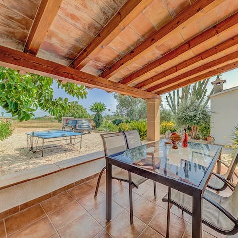 Watch a game of ping pong as you shade yourself on the covered terrace 