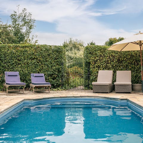 Dive into your pristine heated pool and dry off naturally on the loungers