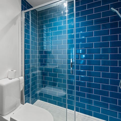 Feel serene after calming walk-in shower in the blue-tiled bathroom