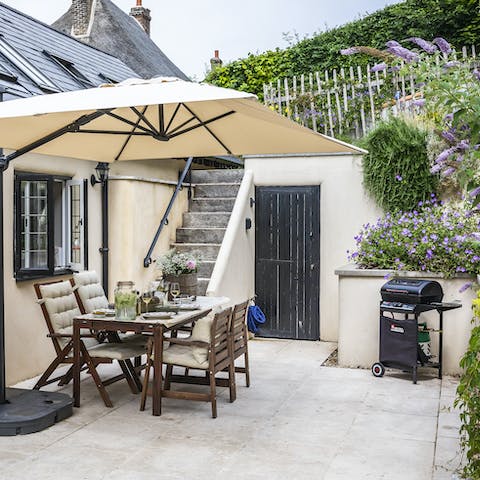 Light up the barbecue and serve up to guests sitting underneath the parasol