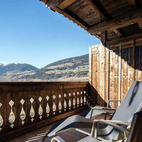 Step out onto the balcony and gaze out at the hilly landscape