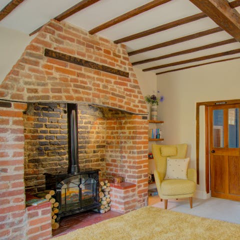 Cosy up in front of the fireplace in the wood-beamed living room after a country walk