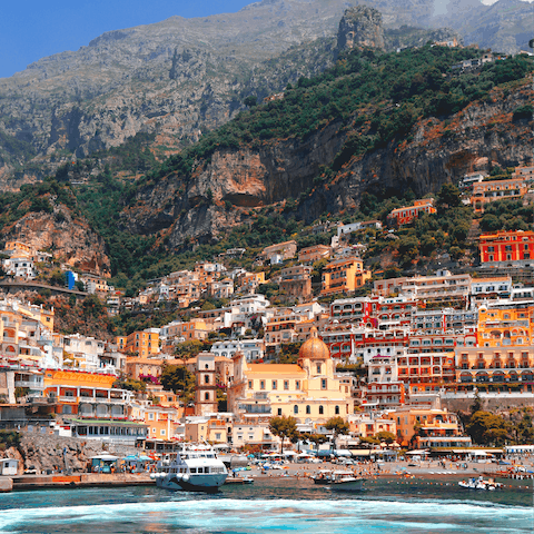 Enjoy strolling through the coastal village of Positano, with colourful houses sprawling up a steep mountain