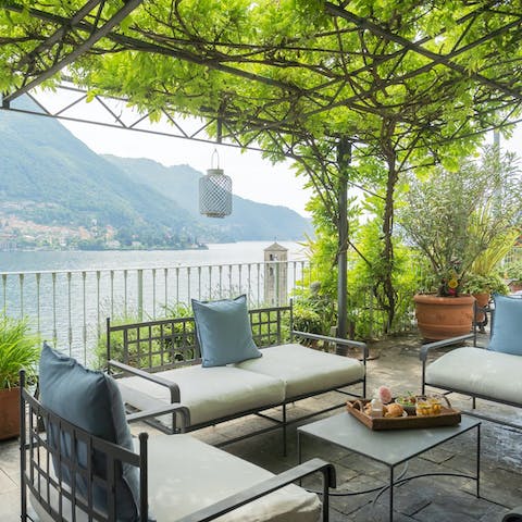 Admire the beautiful lake views from the shade of the vine-covered pergola