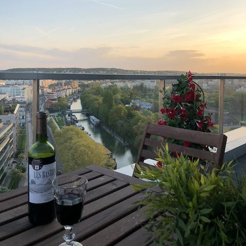Enjoy a glass of wine on the balcony and admire the views of the Seine at sunset