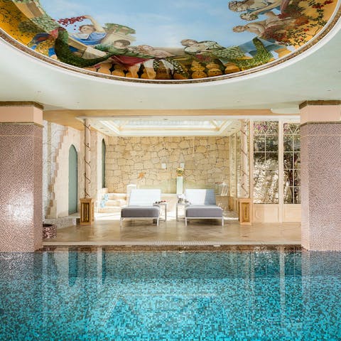 Relax on a lounger while admiring the exquisite art painted on the pool ceiling