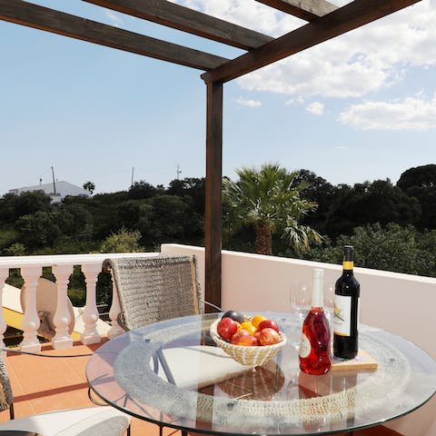 Enjoy a tipple on the balcony, looking out at the sun starting to set behind the trees